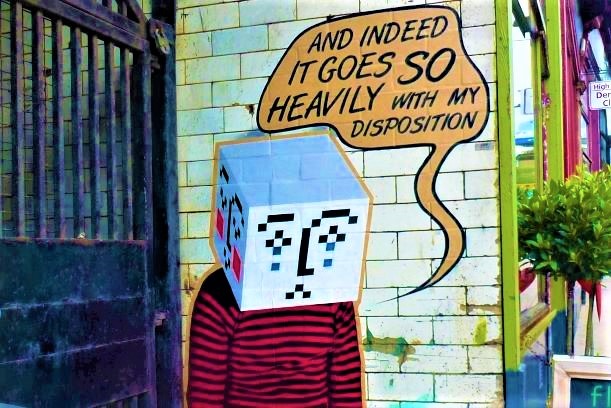 Mural of a person with a box for a head,  with the words 'And indeed it goes so heavily with my disposition'