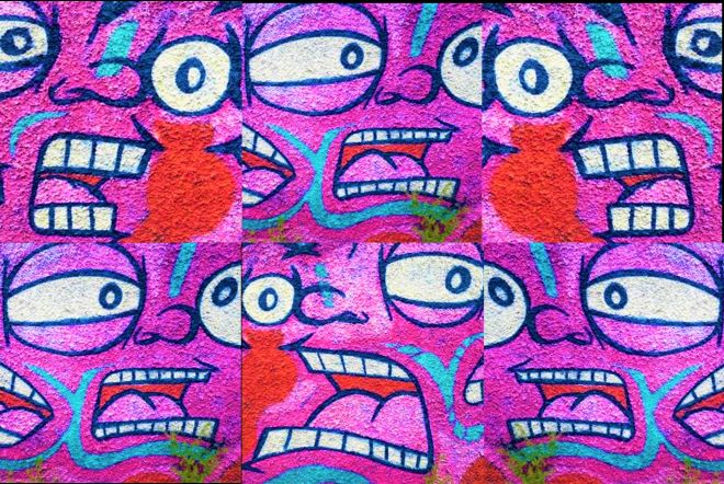 Six cartoon pink faces painted on a wall